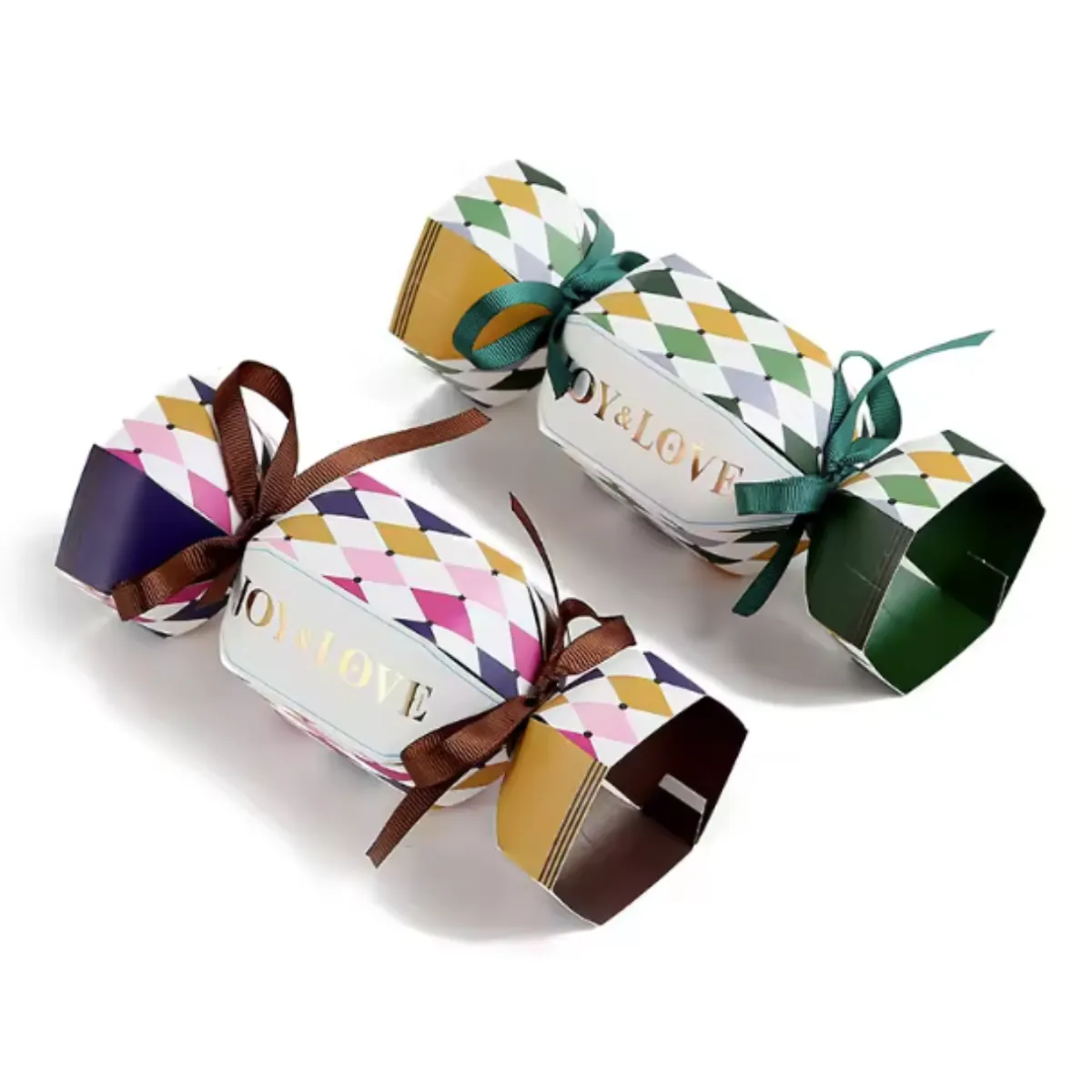 Two decorative harlequin pattern gift crackers tied with green and brown ribbons on white- class=